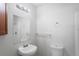 Bathroom with white fixtures including a sink, toilet, vanity and framed mirror at 3209 Kismet Ct, New Port Richey, FL 34655
