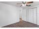 Bedroom with wood-look flooring, ceiling fan with lights, closet and view of adjacent rooms at 3209 Kismet Ct, New Port Richey, FL 34655