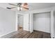 Bedroom with wood-look flooring, ceiling fan with lights, closet and an open doorway at 3209 Kismet Ct, New Port Richey, FL 34655
