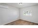 Comfortable bedroom with wood-look flooring, natural light, and mini-split air conditioning at 3209 Kismet Ct, New Port Richey, FL 34655