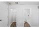 Bright hallway with wood-look flooring and doors to a closet and a bathroom with a standing shower at 3209 Kismet Ct, New Port Richey, FL 34655