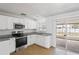 Modern kitchen with stainless steel appliances, granite countertops, and white cabinetry at 3209 Kismet Ct, New Port Richey, FL 34655