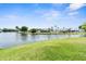 A lakefront backyard featuring a lush lawn and houses on the opposite shore at 3346 Rock Valley Dr, Holiday, FL 34691