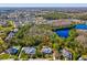 An aerial view of a home with a pool surrounded by trees and other houses at 3733 Wiregrass Rd, New Port Richey, FL 34655