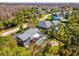 Aerial view of a home with a screened pool, fire pit, and surrounding trees at 3733 Wiregrass Rd, New Port Richey, FL 34655