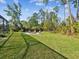 Grassy backyard features a stone fire pit area with chairs for outdoor entertaining at 3733 Wiregrass Rd, New Port Richey, FL 34655