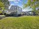 Large, grassy backyard with a screened-in pool and outdoor patio area at 3733 Wiregrass Rd, New Port Richey, FL 34655