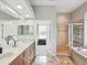 Luxurious bathroom featuring dual vanities, a walk-in shower, and a soaking tub at 3733 Wiregrass Rd, New Port Richey, FL 34655