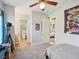 Cozy bedroom featuring a ceiling fan, gray carpet, and an ensuite bathroom at 3733 Wiregrass Rd, New Port Richey, FL 34655