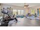 A bright bonus room featuring a ceiling fan, wood laminate floors, and multiple large windows at 3733 Wiregrass Rd, New Port Richey, FL 34655