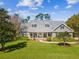 Charming single-story home boasts a covered front porch, dormer windows, and lush landscaping at 3733 Wiregrass Rd, New Port Richey, FL 34655