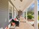 Comfortable front porch featuring brick flooring, cozy seating, and classic white columns at 3733 Wiregrass Rd, New Port Richey, FL 34655