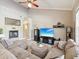 Cozy living room with fireplace, plush sectional sofa, and vaulted ceilings at 3733 Wiregrass Rd, New Port Richey, FL 34655