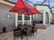 Outdoor dining area with a patio umbrella, fire pit, and covered seating area at 3733 Wiregrass Rd, New Port Richey, FL 34655