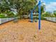 Neighborhood playground with swings, picnic table, wood chip ground cover, and white picket fence at 3733 Wiregrass Rd, New Port Richey, FL 34655