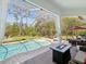 A screened-in backyard pool area with seating and a gas fire pit at 3733 Wiregrass Rd, New Port Richey, FL 34655