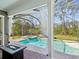 Inviting screened-in pool area with a hot tub and a decorative fire table, perfect for relaxation at 3733 Wiregrass Rd, Trinity, FL 34655