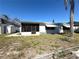 Backyard view of the home, featuring a screened-in porch and landscaping at 4030 Grayton Dr, New Port Richey, FL 34652