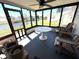 Enclosed porch with water view, featuring a white table, wood chairs and ceiling fan at 4030 Grayton Dr, New Port Richey, FL 34652