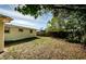 Large, grassy backyard with a privacy fence and mature trees, perfect for outdoor activities at 4938 Fruitwood Loop, Holiday, FL 34690
