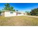 Charming single-story home featuring a red front door and an extended driveway leading to the garage at 4938 Fruitwood Loop, Holiday, FL 34690