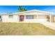 Charming single-story home featuring a red front door and attached garage, perfect for comfortable living at 4938 Fruitwood Loop, Holiday, FL 34690