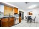 Bright eat-in kitchen with stainless steel appliances, wood cabinets, and a dining area with a sliding glass door at 4938 Fruitwood Loop, Holiday, FL 34690