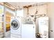 This functional laundry area includes a washer, dryer, and water heater at 4938 Fruitwood Loop, Holiday, FL 34690