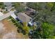 Aerial view of the home with a fenced backyard, screened-in porch, mature trees, and a driveway at 513 Meres Blvd, Tarpon Springs, FL 34689