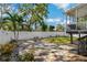 Private backyard featuring a patio area, lush landscaping, and a white fence at 513 Meres Blvd, Tarpon Springs, FL 34689