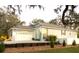 Charming single-story home with a blue door, well-manicured lawn, and welcoming curb appeal at 513 Meres Blvd, Tarpon Springs, FL 34689