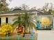 Charming home featuring a cheerful blue door, cozy porch, and a well-manicured, festive front yard at 513 Meres Blvd, Tarpon Springs, FL 34689