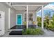 Inviting front porch with blue door, black flooring, seating, and charming beachy decor at 513 Meres Blvd, Tarpon Springs, FL 34689
