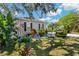 Charming home exterior with well-manicured landscaping, a palm tree and a decorative boat at 513 Meres Blvd, Tarpon Springs, FL 34689