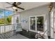 Screened porch featuring an outdoor chair, ceiling fan, and view of the backyard through glass doors at 513 Meres Blvd, Tarpon Springs, FL 34689