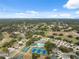 Aerial view of community with pool, tennis courts, lush green trees, and pond at 5492 Legend Hills Ln, Spring Hill, FL 34609