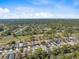 Extensive aerial view showing rooftops of a suburban area, surrounded by dense trees, and fairways at 5492 Legend Hills Ln, Spring Hill, FL 34609