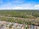 An aerial shot of a neighborhood surrounded by lush green trees at 5492 Legend Hills Ln, Spring Hill, FL 34609