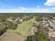 Aerial view of golf course, community, lush green trees, and fairways at 5492 Legend Hills Ln, Spring Hill, FL 34609