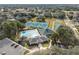 Aerial view of community pool, playground, tennis courts, parking and community buildings at 5492 Legend Hills Ln, Spring Hill, FL 34609