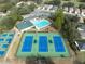 Overhead photo exhibiting an attractive pool area, tennis courts, and well-maintained landscaping at 5492 Legend Hills Ln, Spring Hill, FL 34609