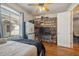 Cozy bedroom featuring a ceiling fan, hardwood floors, and large window at 5492 Legend Hills Ln, Spring Hill, FL 34609
