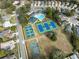 Aerial shot showing a swimming pool, tennis courts, a basketball court and manicured lawns at 5492 Legend Hills Ln, Spring Hill, FL 34609