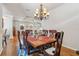 Elegant dining area with a wooden table, six chairs, and a chandelier, perfect for Gathering gatherings at 5492 Legend Hills Ln, Spring Hill, FL 34609