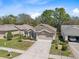 Aerial shot of a home featuring a manicured lawn, a two-car garage and mature trees at 5492 Legend Hills Ln, Spring Hill, FL 34609