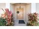 Inviting front entry with double doors, decorative wreath, and colorful tropical plants at 5492 Legend Hills Ln, Spring Hill, FL 34609
