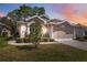 Charming home featuring manicured landscaping, neutral stucco, and attached two-car garage at 5492 Legend Hills Ln, Spring Hill, FL 34609