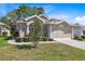 Charming home featuring manicured landscaping, neutral stucco, and attached two-car garage at 5492 Legend Hills Ln, Spring Hill, FL 34609