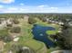 Beautiful aerial view of a lush golf course with a scenic pond and fountain feature at 5492 Legend Hills Ln, Spring Hill, FL 34609
