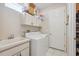 Bright laundry room features white washer, dryer, utility sink, and ample cabinet space for storage at 5492 Legend Hills Ln, Spring Hill, FL 34609